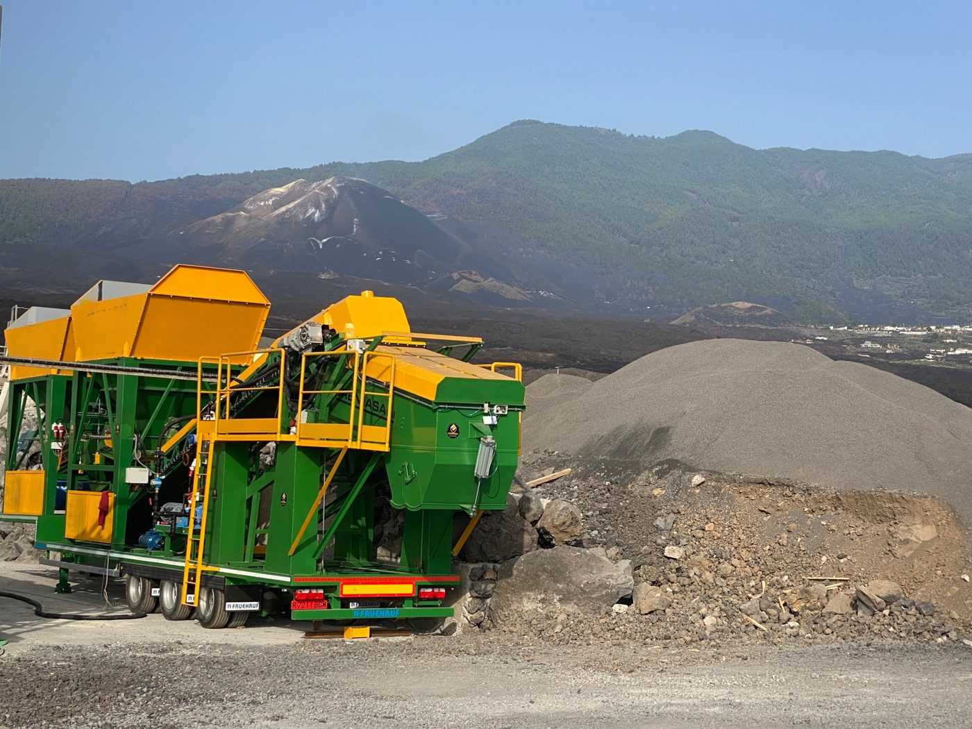 Fabremasa mobile plant installed on La Palma, with the volcano and the lava flow in the background